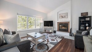 A living room with a fireplace, a television, and a bookshelf.