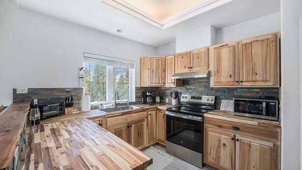 A modern kitchen with wooden cabinets, a large island, and a skylight.