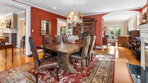 A dining room with a wooden table, chairs, and a chandelier. - Spacious Historic Manor with Chef's Kitchen • Horse-Friendly (Southern Pines)