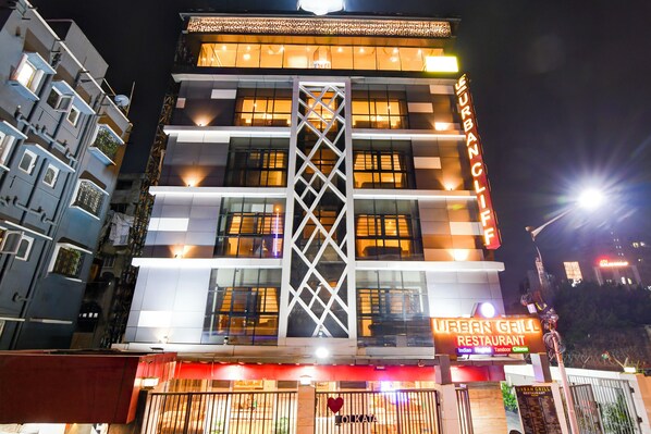 Un immeuble à plusieurs étages, sur lequel on peut lire l’enseigne « Urban Grill Restaurant », ce qui indique qu’il s’agit d’un établissement où l’on peut prendre ses repas.
