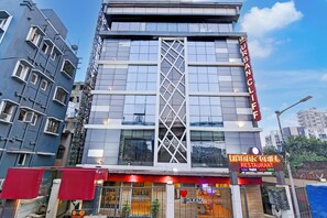 Un bâtiment moderne avec une enseigne indiquant « URBAN CLIF HOTEL » et « URBAN GRILL RESTAURANT », proposant une cuisine indienne, écossaise (haggis) et chinoise.