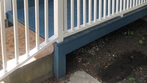 A blue house with a white porch and a white door. - Charming studio apartment in Whiteville (Whiteville)