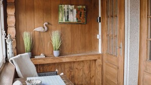 Un interior de madera con una mesa de comedor, sillas, una planta en maceta y una puerta.
