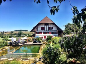 Ein traditionelles Fachwerkhäuschen mit Schwimmbad und Sitzgelegenheit im Freien.