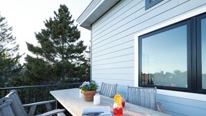 Eine Terrasse im Freien mit Tisch, Stühlen, einem Blumentopf und einer Zeitschrift.