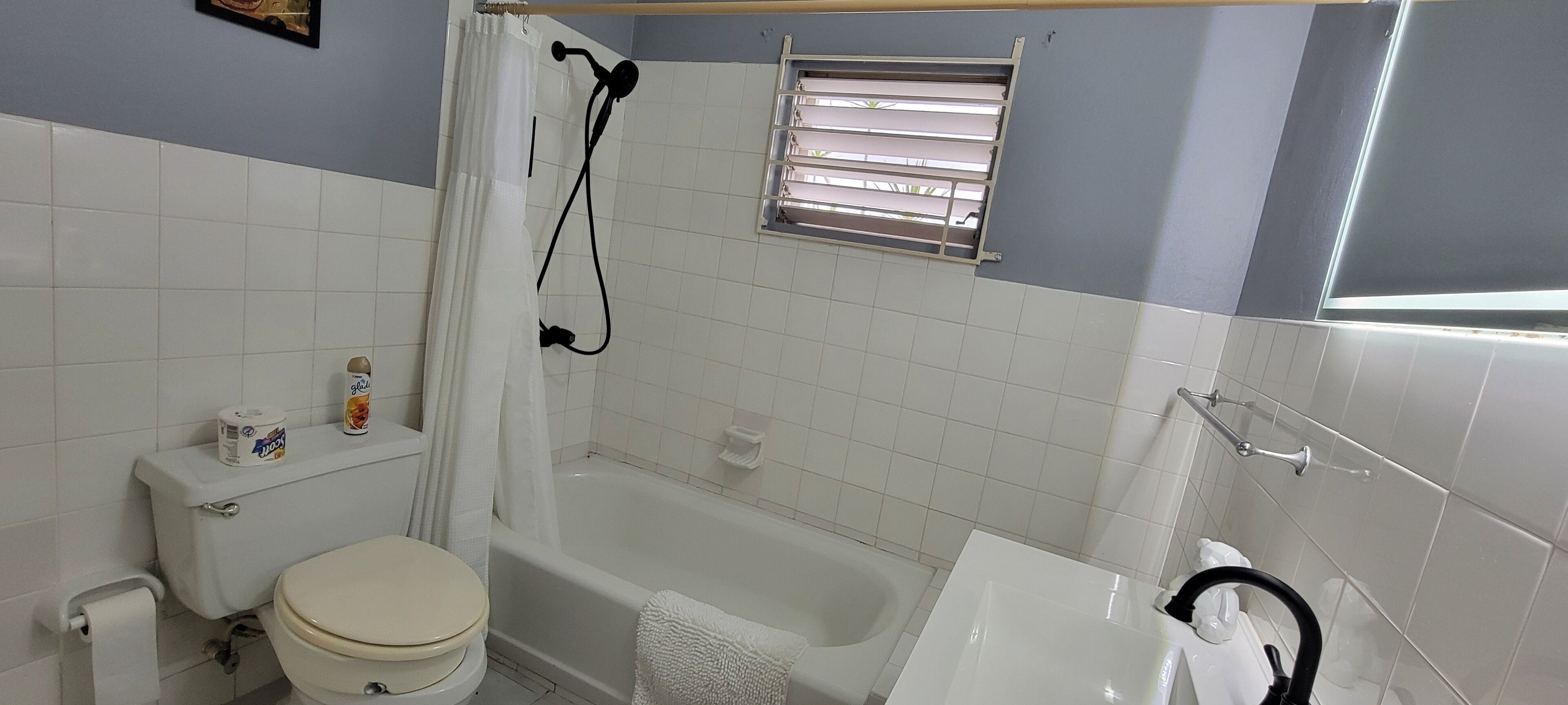 A bathroom with a toilet, bathtub, and sink.