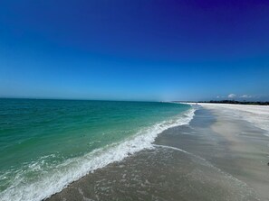 A beach with clear turquoise water and a wide sandy shore.