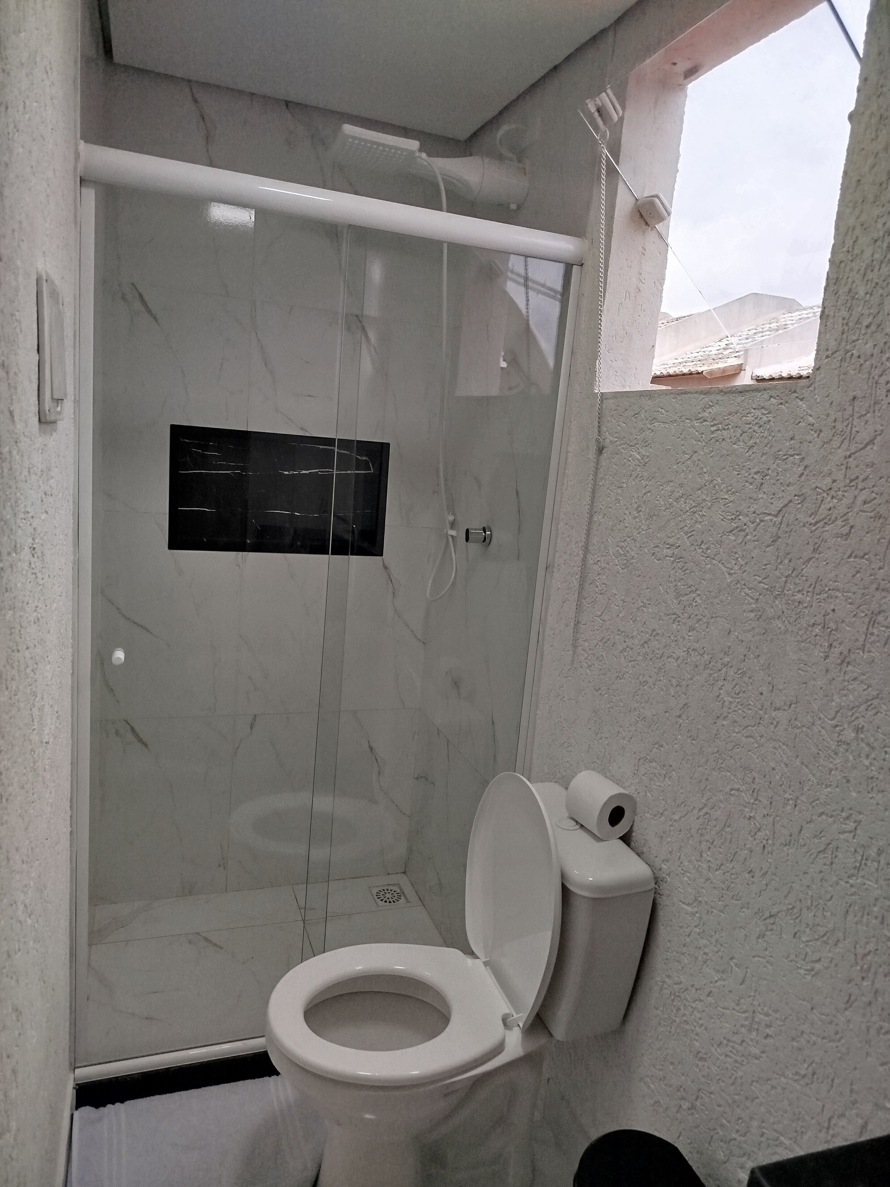 Une salle de bain équipée de toilettes, d’une douche et d’un panneau de commande mural.