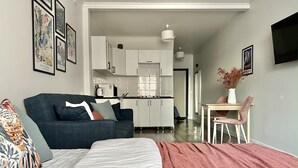 A modern apartment with a bed, sofa, dining table, and kitchenette. - Cozy studio with WiFi and AC in center of Almaty (Almaty)