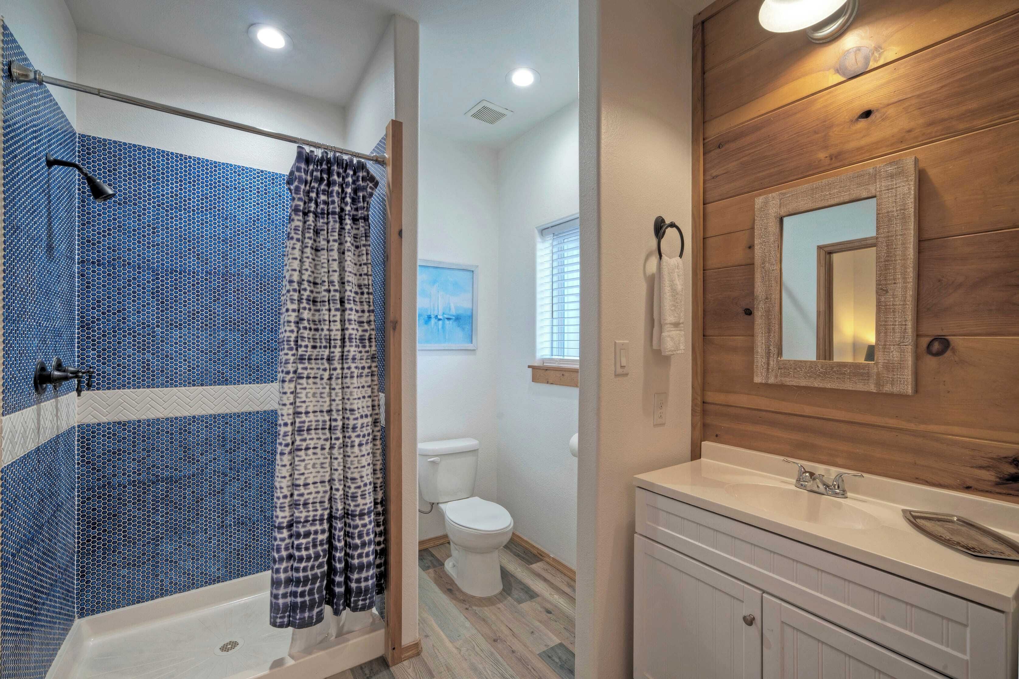 A bathroom with a shower, toilet, and sink.
