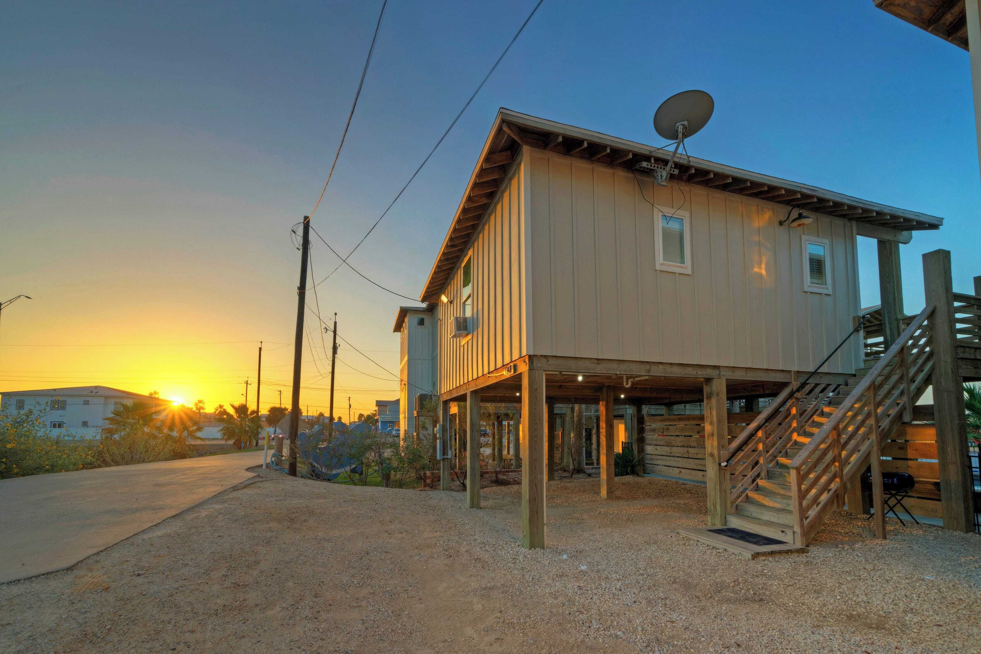 Una casa de dos pisos con terraza de madera y antena parabólica.