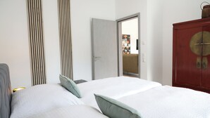 A hotel room with a large bed, a wardrobe, and a door leading to a balcony.