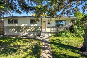 A single-story house with a front porch, a mailbox, and a visible number 2428 on the door. - Gather & Stay- whole house, full kitchens, free parking, cozy, 6BR, sleeps 16 (Calgary)