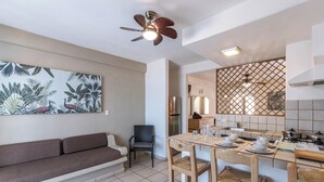 A modern kitchen with a dining area, a sofa, and a ceiling fan. - Torreblanca Beach Hotel and Suites Guayabitos - Desayuno y Comida Incluido (Rincón de Guayabitos)