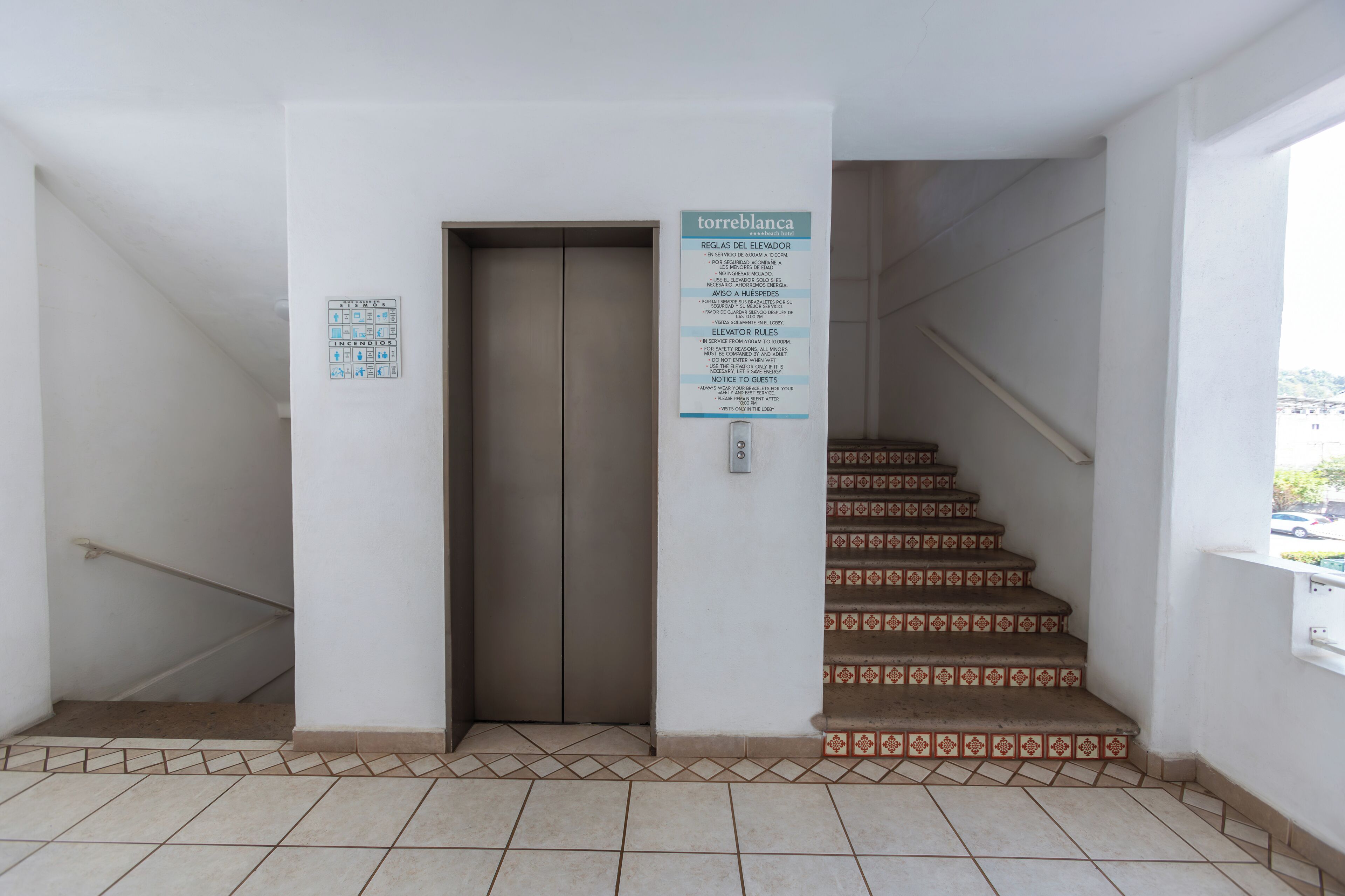 An elevator with a sign detailing rules and emergency procedures.