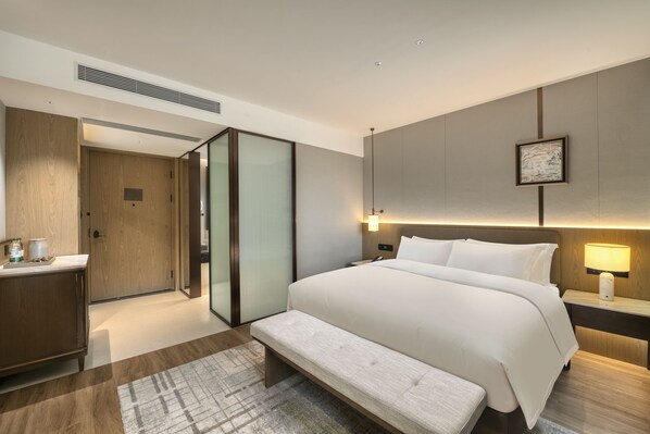 A modern hotel room with a large bed, bedside tables, a bench, a desk, and a wardrobe. - Wyndham Garden Shaoguan Xinfeng (Shaoguan)