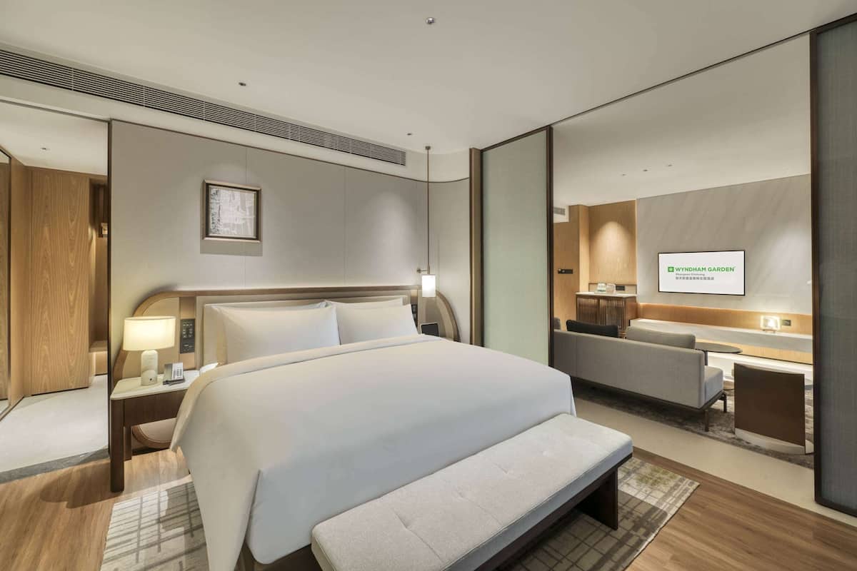 Een moderne hotelkamer met een groot bed, een bureau, een bank en een televisie.