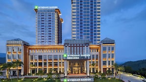 Un hôtel à plusieurs étages, doté d’une entrée imposante et d’une enseigne indiquant « WYNDHAM GARDEN ».