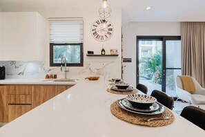 Enjoy cooking in this well-equipped kitchen with a large window and pendant light.
