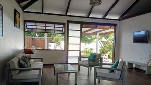 Un vaste espace de vie doté d’un plancher en bois, d’un canapé, d’une table basse et d’un téléviseur.