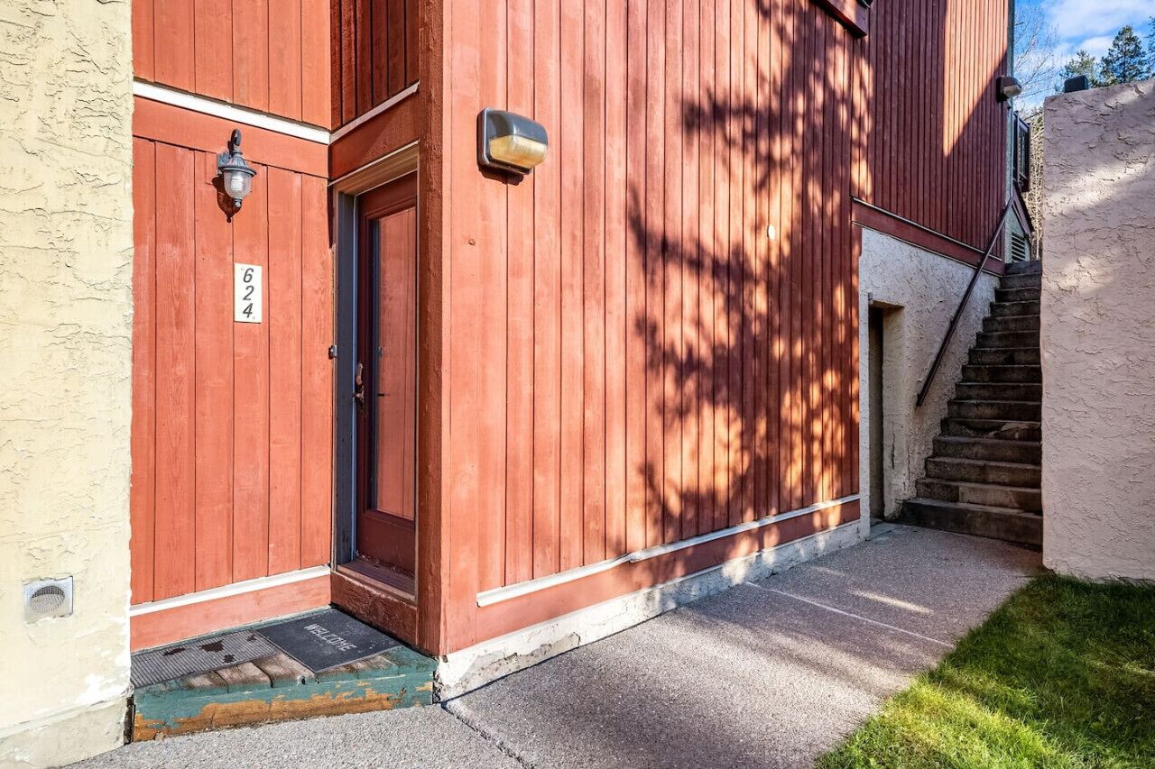 A red wooden building with a door and a number '624' sign.