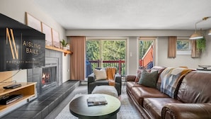 Ein modernes Wohnzimmer mit Kamin, Ledersofa und Flachbildfernseher.