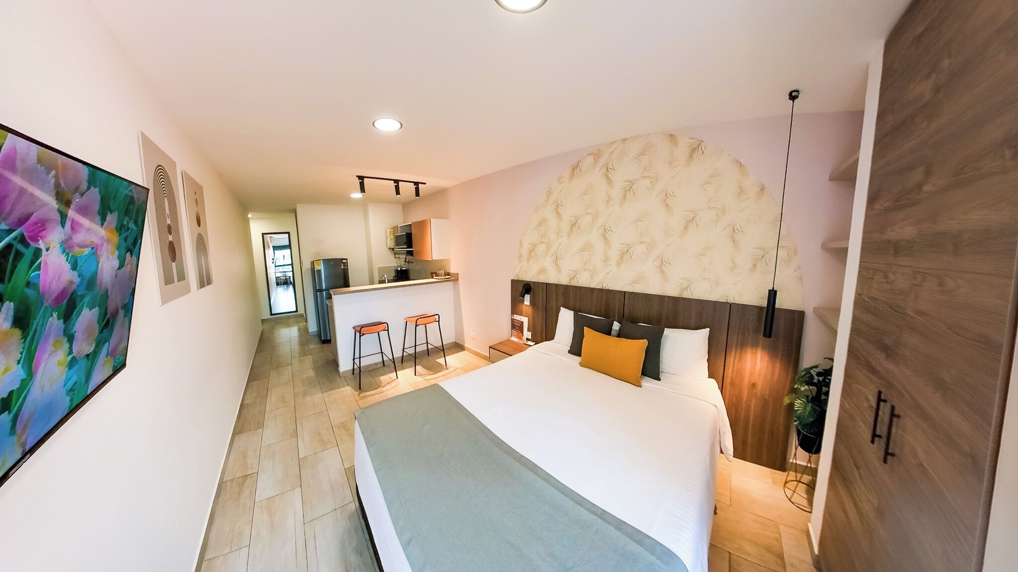 Habitación de hotel con una cama grande, una kitchenette pequeña y vistas al baño contiguo.