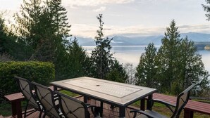 A deck with a table and chairs overlooking a lake and mountains. - Hood Canal Waterfront Group Retreat (Silverdale)