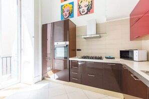 A modern kitchen with a built-in oven, microwave, and gas stove.