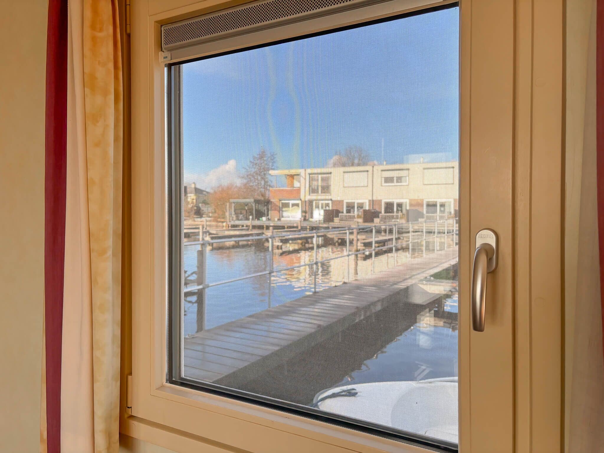 A window with a view of a dock and buildings.