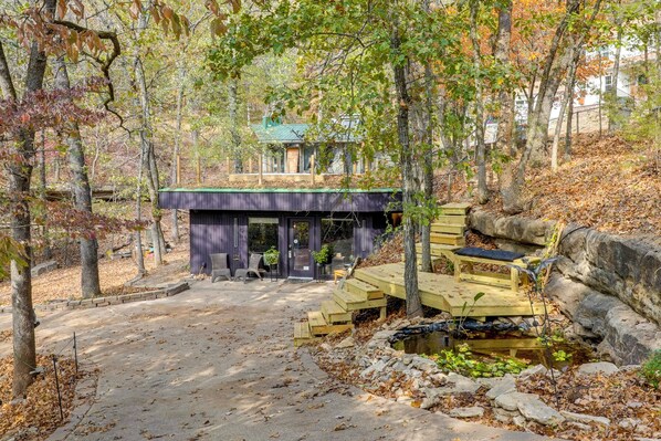 A cabin with a green roof, surrounded by trees and a small pond. - Grill & Rooftop Deck: Cozy Hideaway in Garfield (Garfield)
