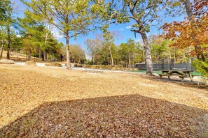 A park with picnic tables, a fenced area, and trees with autumn leaves. - Grill & Rooftop Deck: Cozy Hideaway in Garfield (Garfield)