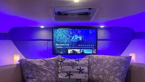 A bedroom with a bed, a television on the wall, and a ceiling air conditioner. - A romantic night for couples in the yacht in Marina del Rey, Los Angeles (Marina del Rey)