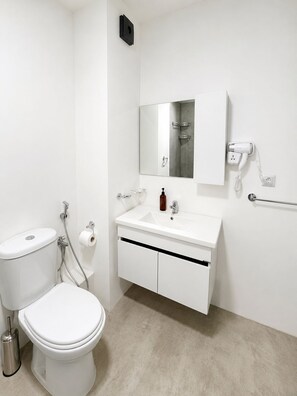 Ein modernes Badezimmer mit Toilette, Waschbecken und Spiegel.