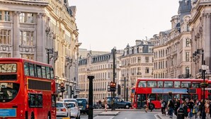 A busy urban street with double-decker buses and classic architecture.