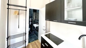 A modern kitchen with black cabinets, a white countertop, and a built-in oven.