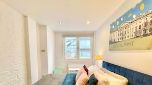 A bedroom with a bed, a window, a painting, and a radiator. - Cozy 1 bedroom flat near Tower Bridge (Greater London)