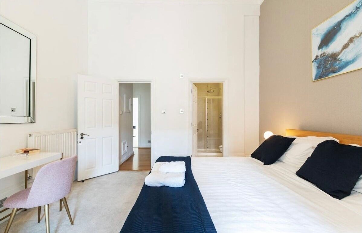 Een hotelkamer met een bed, een bureau, een stoel en een douche.