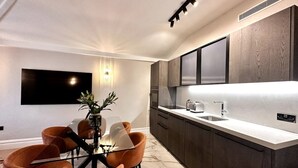 A modern kitchen with dark cabinetry, a white countertop, and a built-in oven. - Lux Top floor 3 Bed Flat near Marble Arch (Greater London)