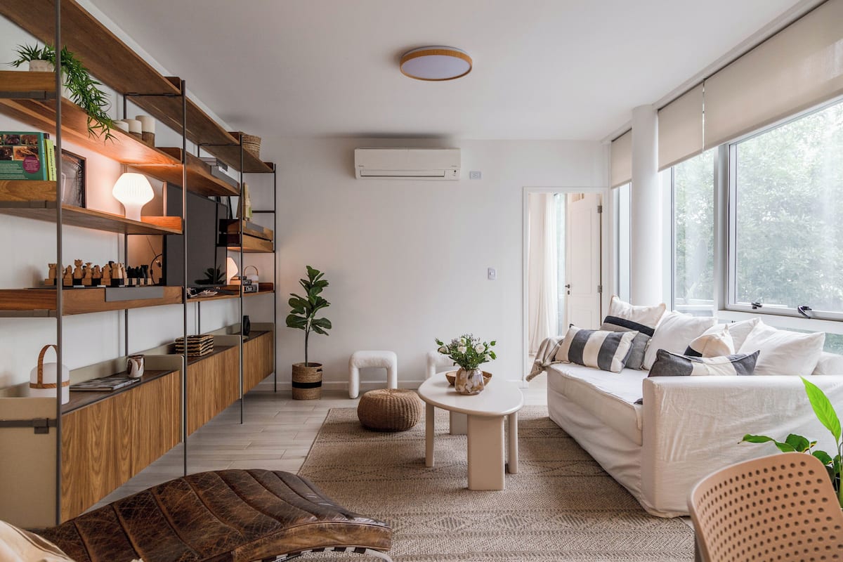 A modern living room with a sofa, coffee table, and shelves.