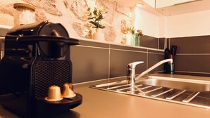 A kitchen with a coffee maker, a toaster, a sink, and a stone wall. - Dubonnet - Coeur de ville (Brignoles)