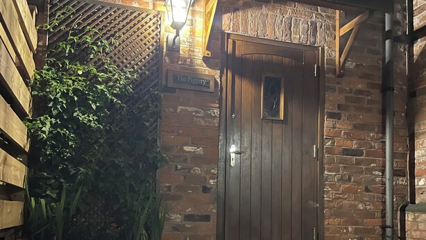 A brick building with a wooden door, a potted plant, and a gravel pathway. - THE PIGGERY CHESHIRE. The perfect place to get away from it all (Smallwood)
