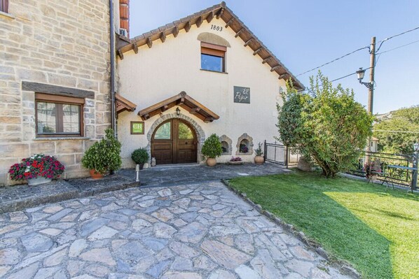 A stone building with a wooden door and a number '1803' above it. - Rustic House in the Pyrenees, ideal for families (Senegüé)