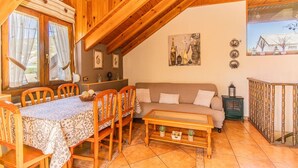 A cozy wooden interior with a dining table, chairs, a sofa, and a coffee table. - Rustic House in the Pyrenees, ideal for families (Senegüé)