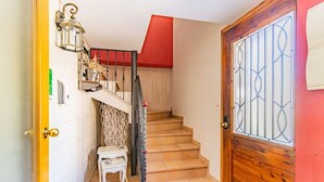A staircase with a wooden handrail, a small chair, and a decorative wall shelf. - Rustic Duplex in the Pyrenees - Garden & Parking (Senegüé)