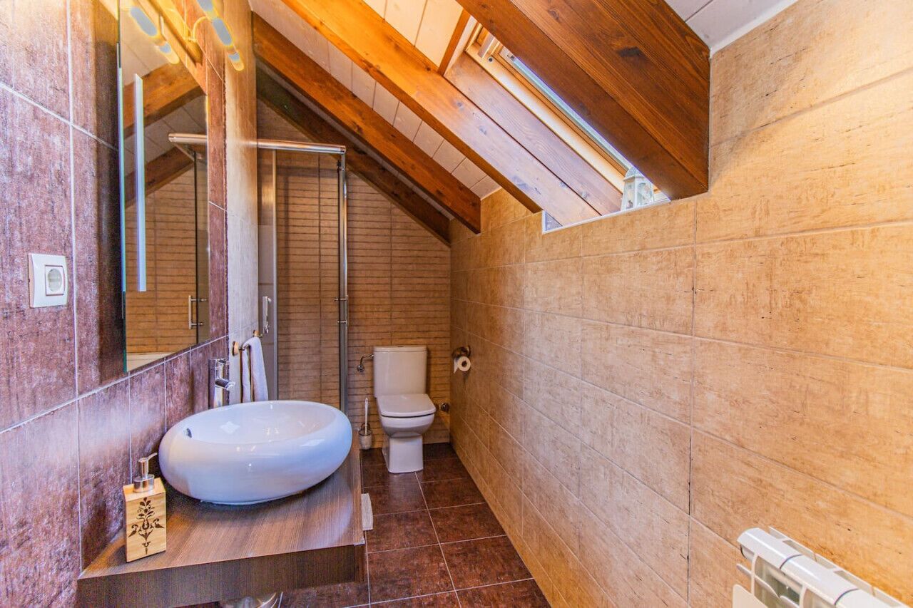 Un baño moderno con un lavamanos grande, inodoro y ducha.