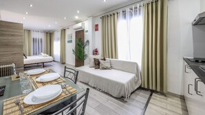 A modern hotel room with a dining area, a sofa bed, and a kitchenette. - Classy Studio close to Retiro Park, Madrid (Madrid)