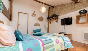 A bedroom with a bed, a television, a fan, and decorative wall hangings. - Spacious 190 m² Holiday Home, Billiards, Memorable Gatherings near Canal du Midi (lagarde)