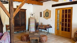A traditional room with a wooden ceiling, a chessboard, a dartboard, and a patterned tablecloth. - Spacious 190 m² Holiday Home, Billiards, Memorable Gatherings near Canal du Midi (lagarde)