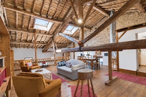 A spacious loft with a high wooden ceiling, a cozy seating area with a sofa and armchairs, and a dining table. - Spacious 190 m² Holiday Home, Billiards, Memorable Gatherings near Canal du Midi (lagarde)